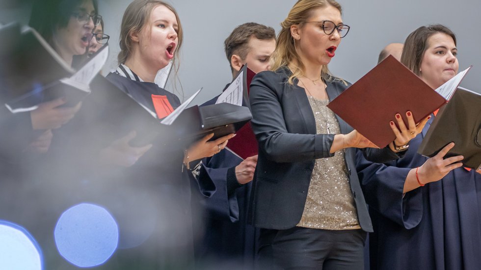 Chór Akademicki UŁ - Kobiety i mężczyźni śpiewający, trzymający nuty
